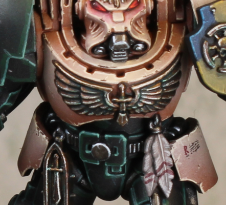 Muted gold chest aquila with dark recesses and greenish weathering